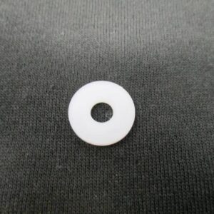 Small white plastic washer on black fabric