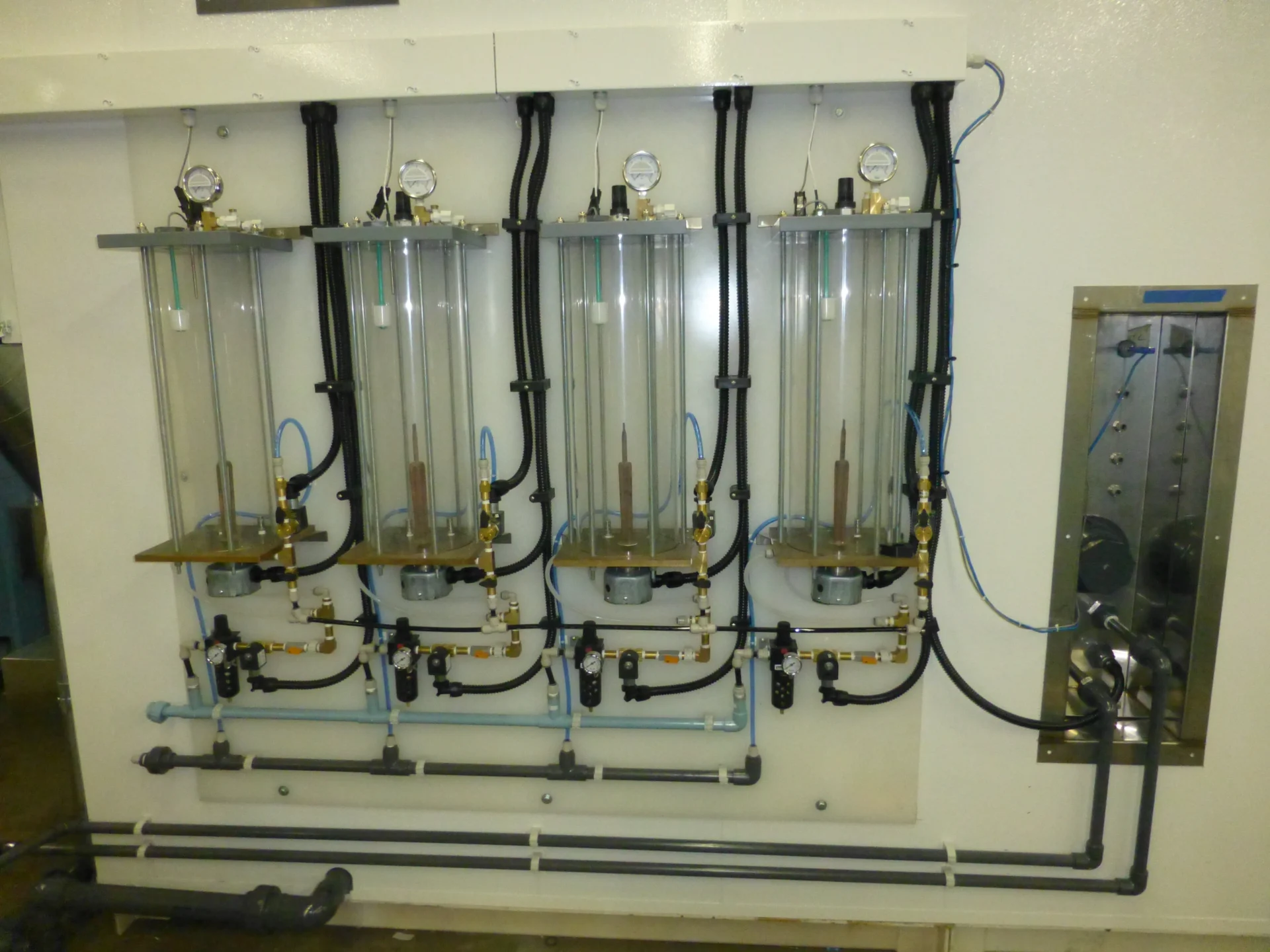 Four clear acrylic bubble towers with pressure gauges and air regulators incorporating elements of ASTM B117 fog generation practices.